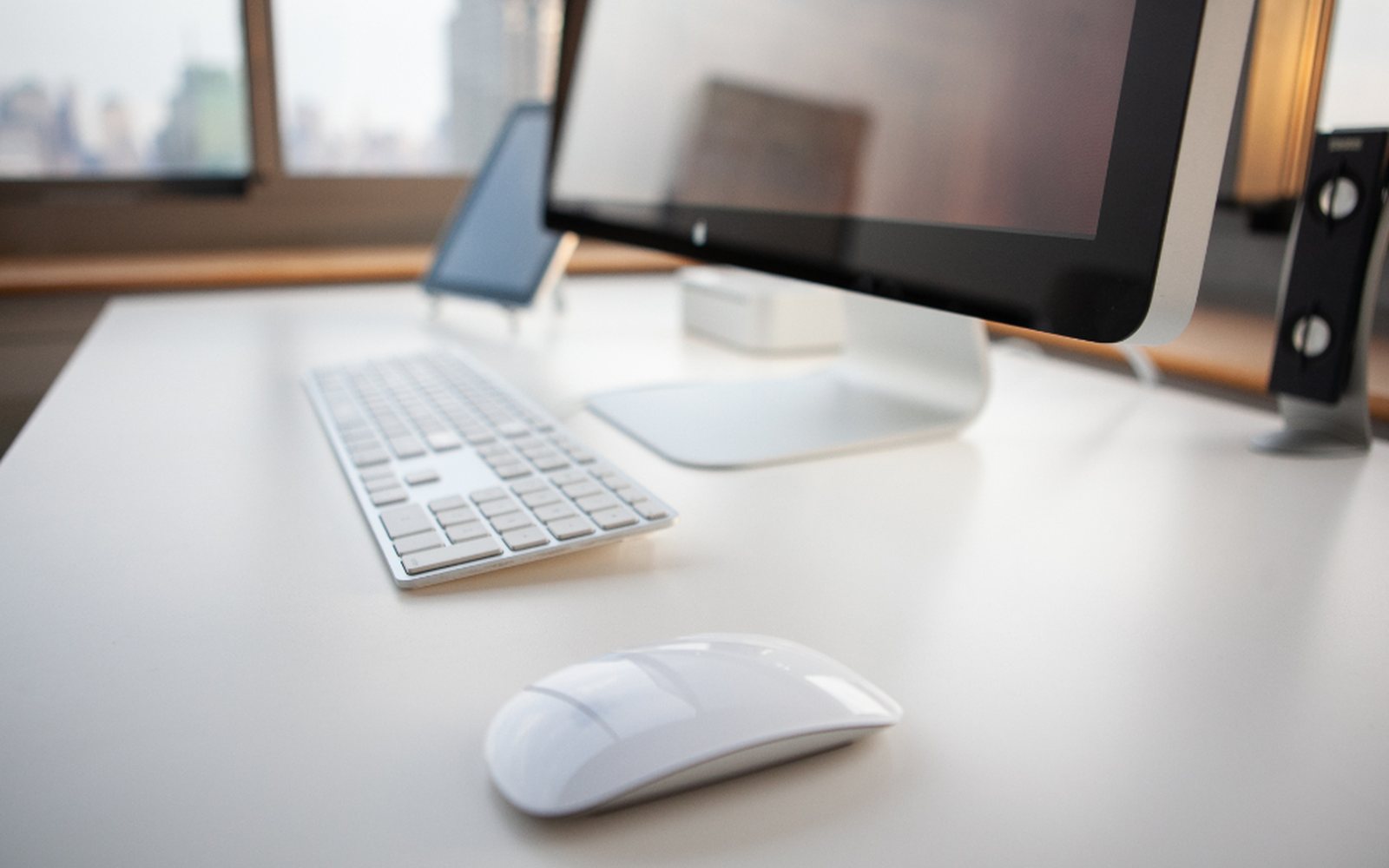 Desktop computer, keyboard, and mouse on a bright, uncluttered desk.