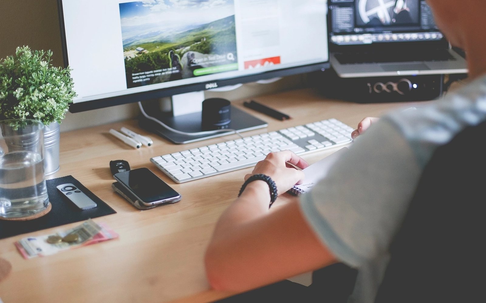Designer building a website layout across two desktop monitors.