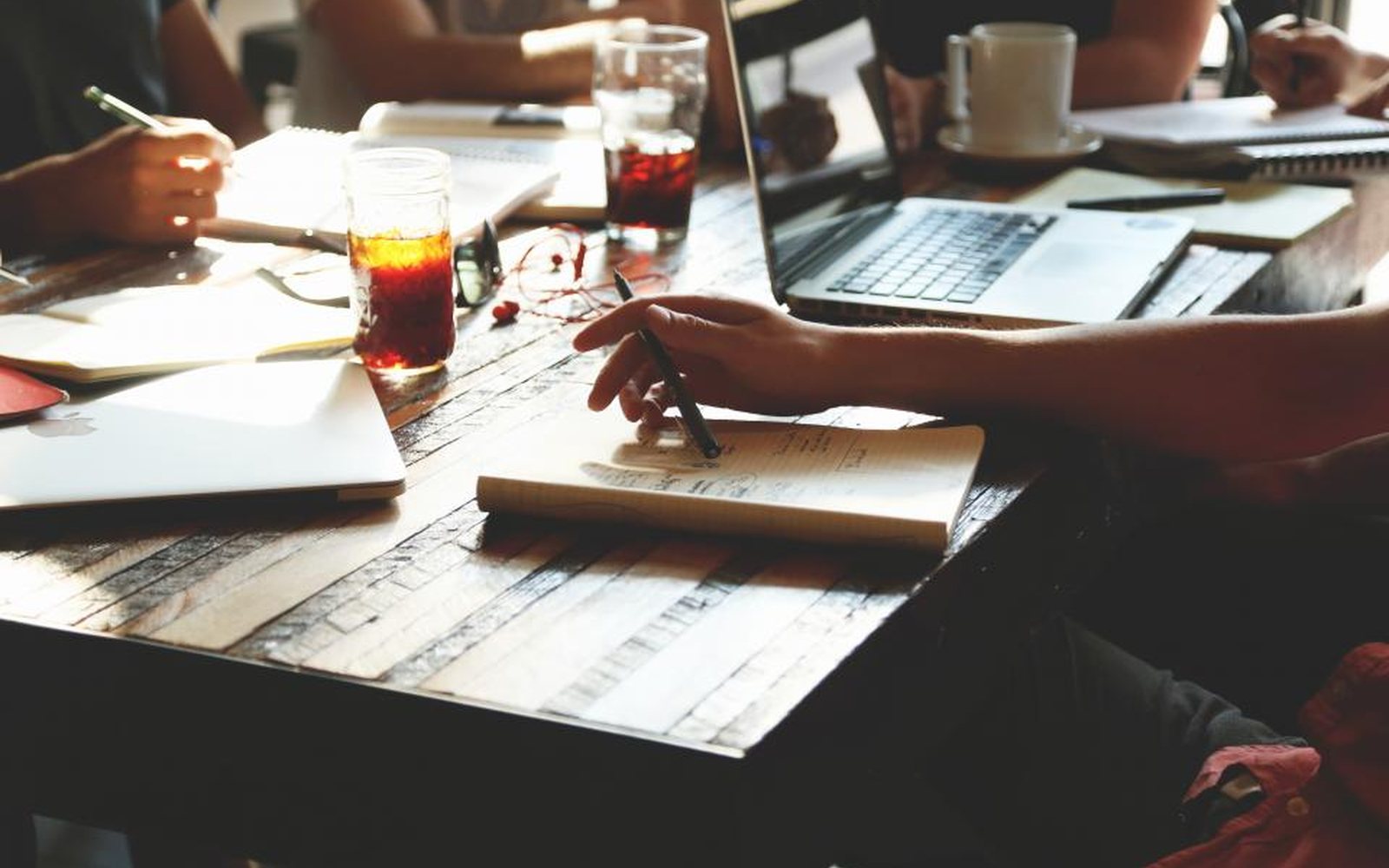 Team reviewing printed documents and a laptop around a table