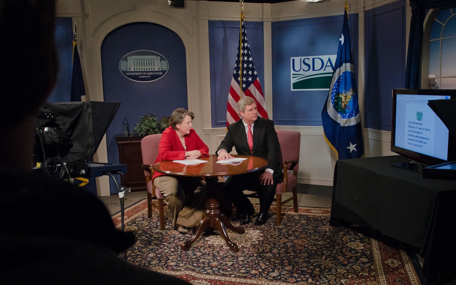 Television studio interview set with camera and prompter monitors.